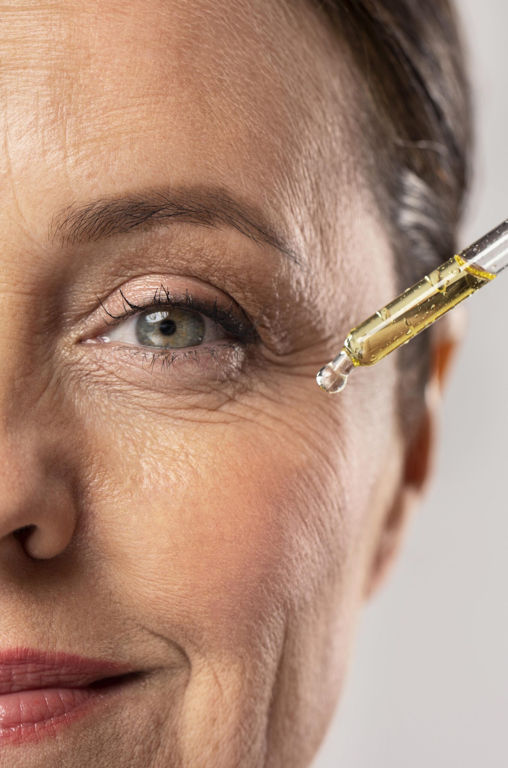 smiley elder woman using serum her eye wrinkles scaled